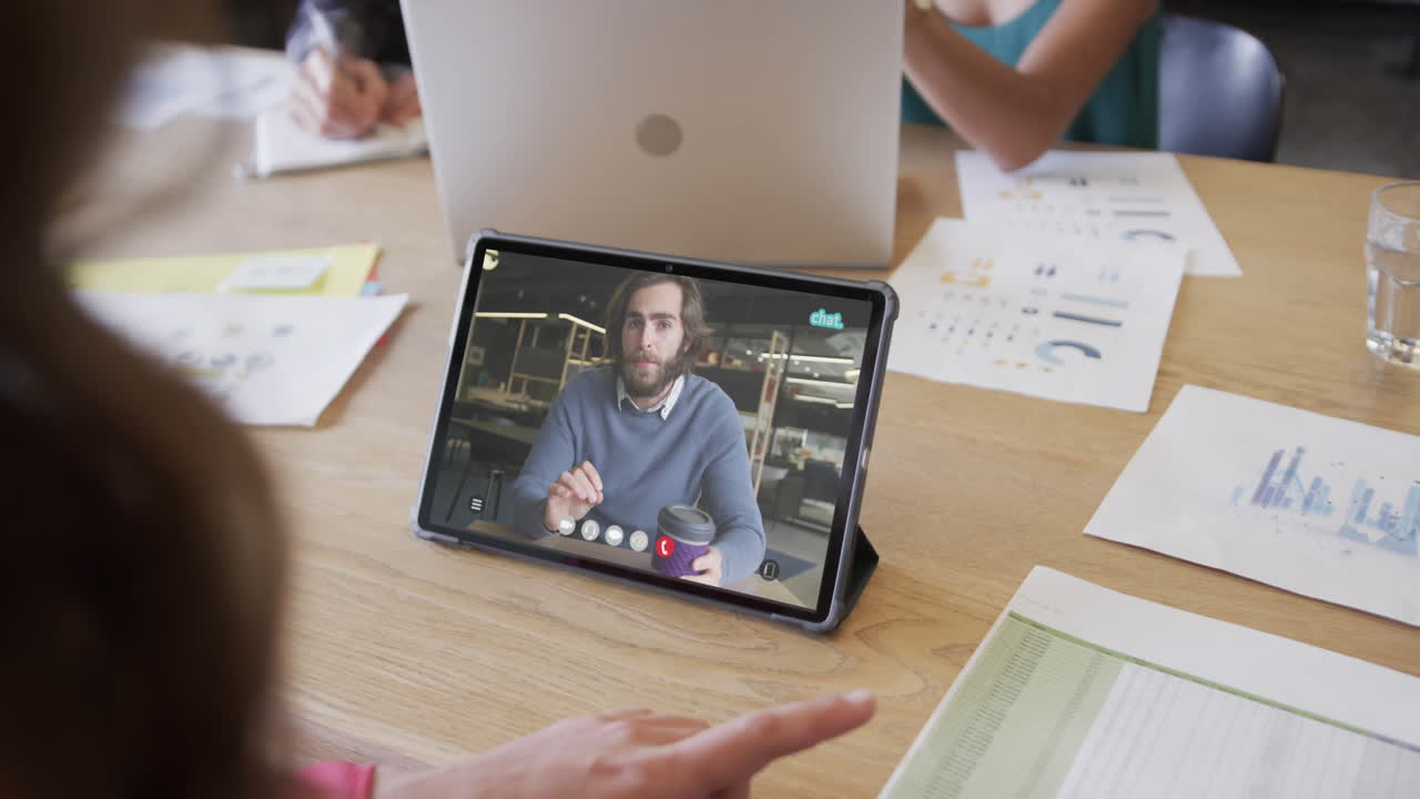 mujer de negocios caucásica en una videollamada con un colega caucásico en la pantalla