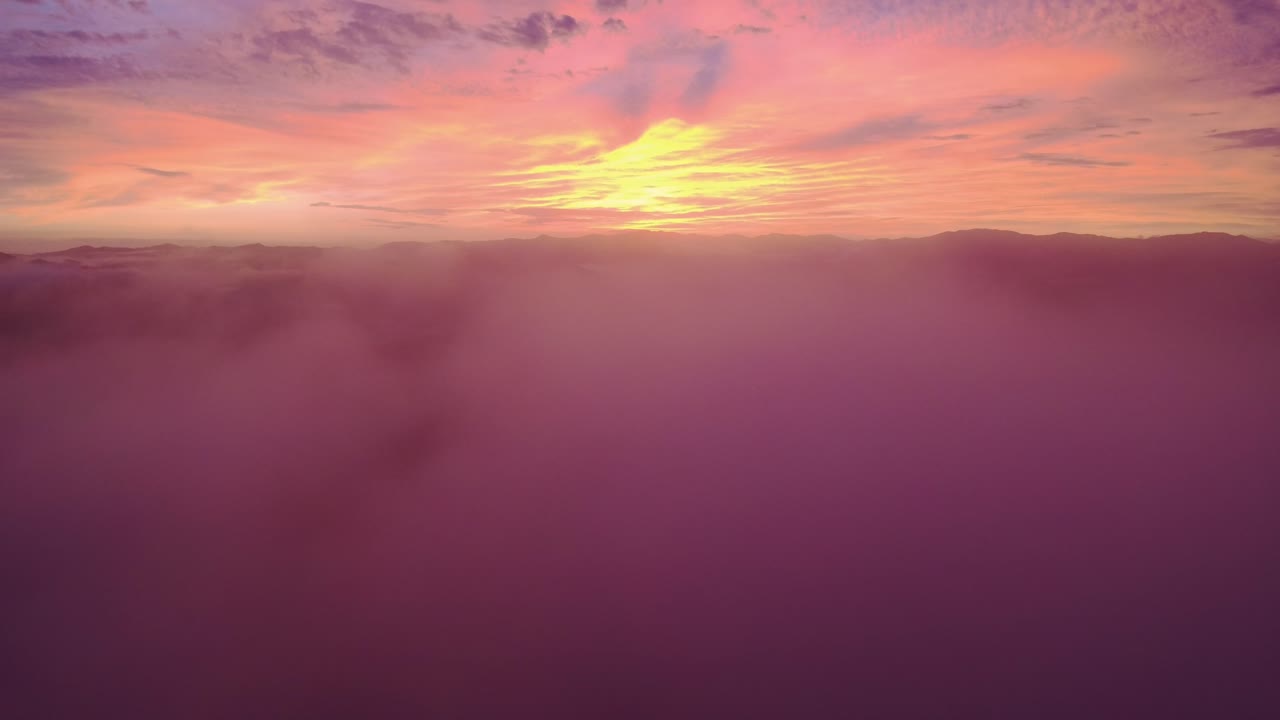 pintoresca colorida puesta de sol roja brillante en el horizonte con nubes mullidas en primer plano, costa rica vuelo de avión no tripulado 4k