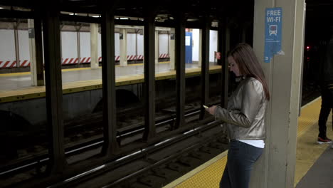 Junge-Attraktive-Frau-Wartet-Darauf,-Dass-Die-U-bahn-An-Einer-New-Yorker-U-bahnstation-Ankommt