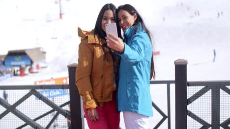 dos mujeres jóvenes riéndose de su selfie