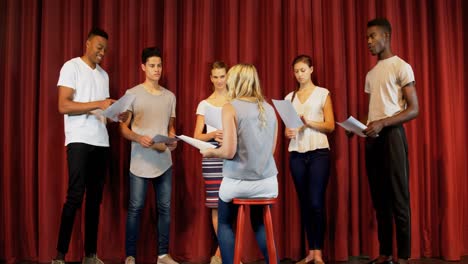 Actors-discussing-their-scripts-on-stage-4k