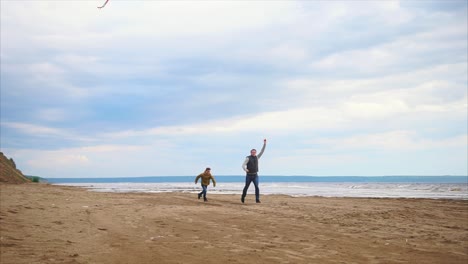 father and son flying a kite on the beach