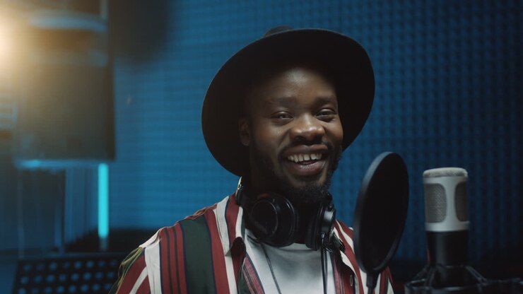 Young Good Looking Cheerful Man Singer Taking Off Headphones And Smiling To The Camera After Recording A Song In The Sound Studio