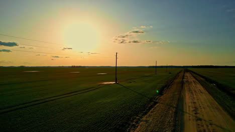 Paisaje-Rural-Tranquilo-Con-Carreteras,-Puesta-De-Sol-Y-Postes-De-Electricidad