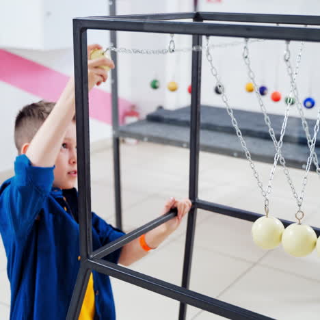 children at the science center experimenting with newton's cradle. the concept of physics. museum of science