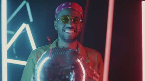 man with disco ball under neon lights