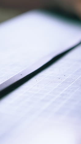 cu: experienced designer draws dots on black leather strip with special pen in workshop extreme close view