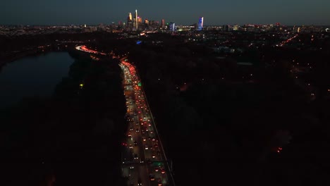 traffic jam at night with city skyline in distance
