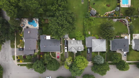 Aerial-ascend-rising-top-down-perspective-above-suburban-neighborhood-with-cars-and-cyclist