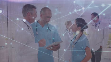 animation of dots connected with lines over multiracial doctors discussing over digital tablet