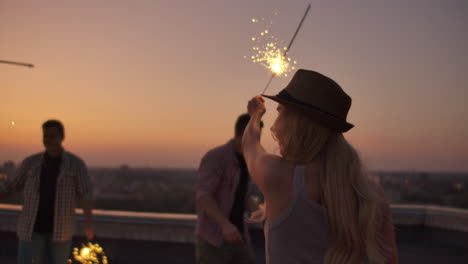 una compañía de jóvenes rusos levantan las manos y saltan al techo con una gran luz bengalí en las manos. es una fiesta loca por la noche.