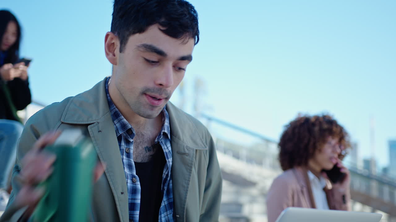 Young Man Working on Laptop and Drinking Coffee Outdoors