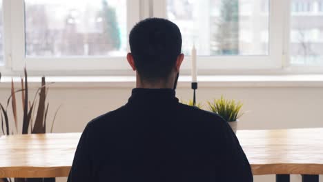 man sitting at a table by a window