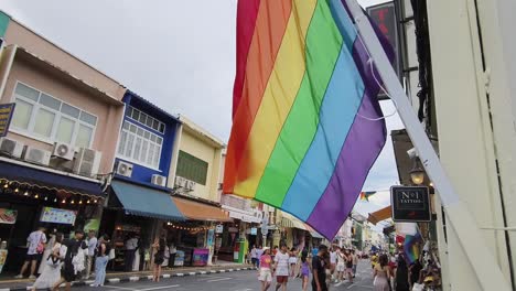 gay pride flag flying high on a street in thailand