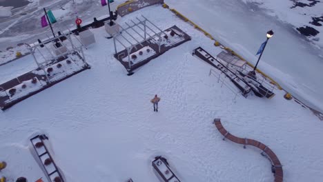 Junge-Frauen-Aus-Der-Luft,-Die-Einen-Morgensonnenaufgang-Auf-Einem-Winterdock-Genießen