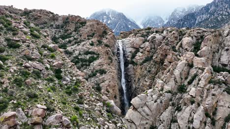 slow motion water fall with mountains covered on snow in the background at palm springs desert ca