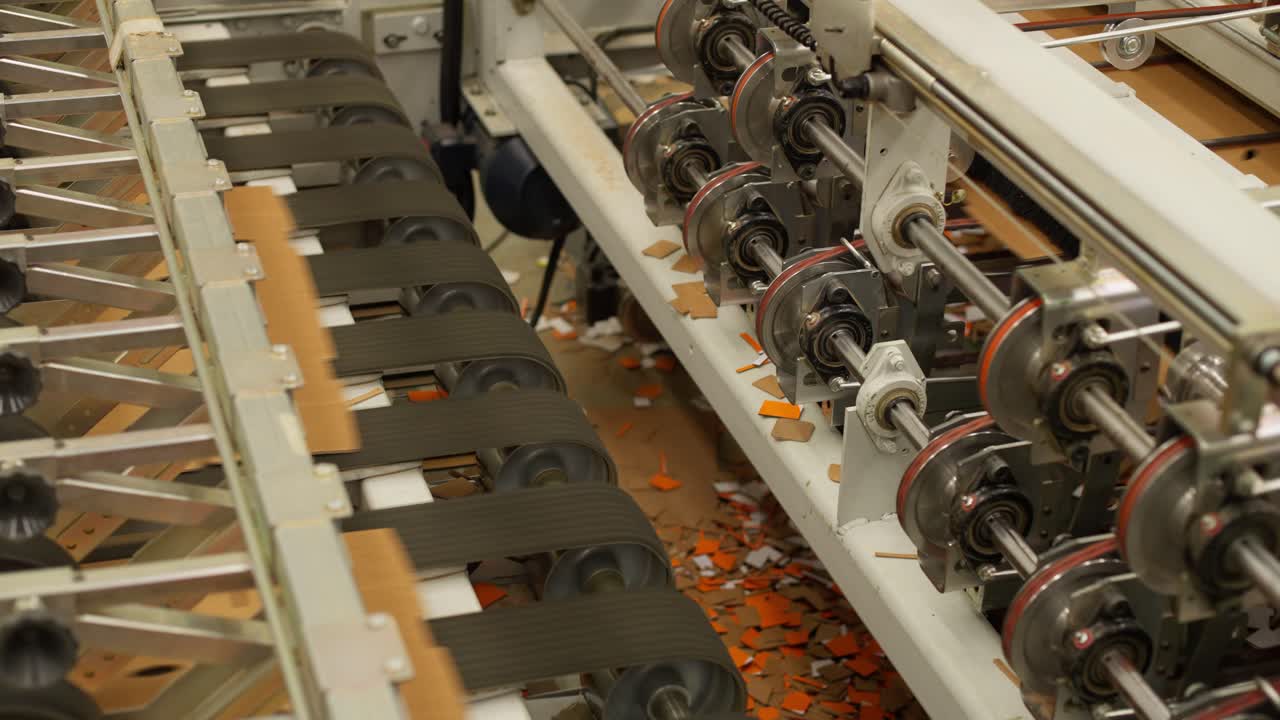 CLOSE UP SHOT OF CARDBOARD BOXES COMING OUT OF A MACHINE