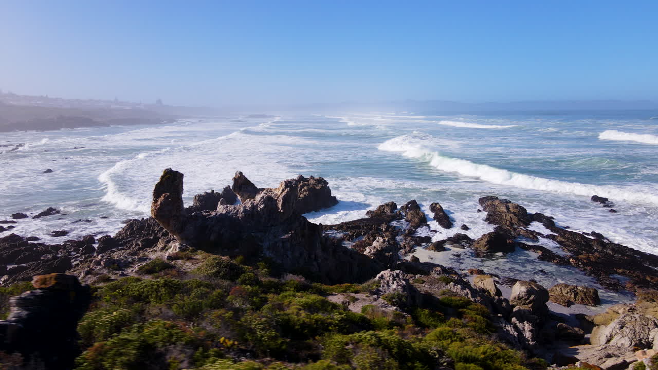 Rock formations along scenic Hermanus coastline - aerial trucking shot overlooking Walker Bay, Overstrand