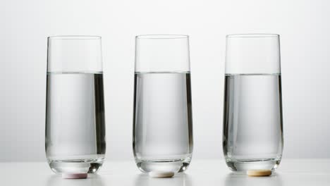 three glasses of water with pills