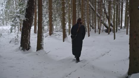 Mädchen-Mit-Zopf-Und-Langem-Schwarzen-Mantel-Geht-Durch-Den-Schnee-In-Der-Natur