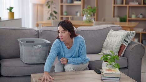 woman folding clothes on a couch in her living room