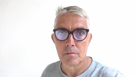hombre blanco de mediana edad con un aspecto intenso se quita las gafas