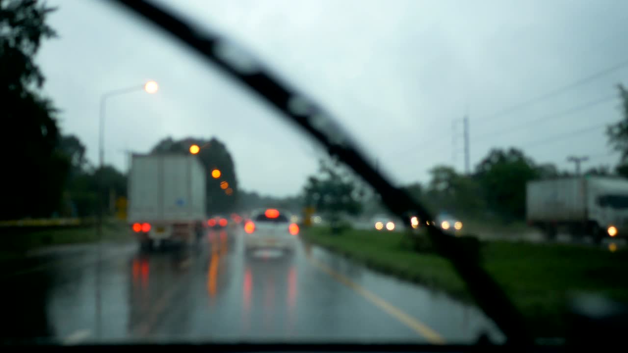 저녁에 흐릿한 배경과 가운 보케와 함께 비에 길을 운전