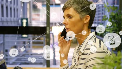 animación de teléfonos conectados e iconos de música sobre una mujer de negocios caucásica hablando en un teléfono inteligente