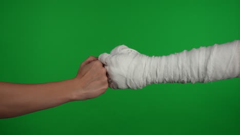 fist bump with bandaged hand on green screen