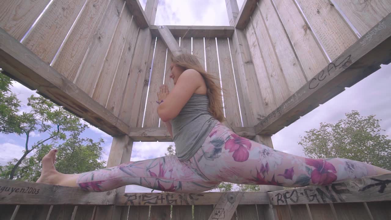 hermosa joven, equilibrando su cuerpo en una posición dividida