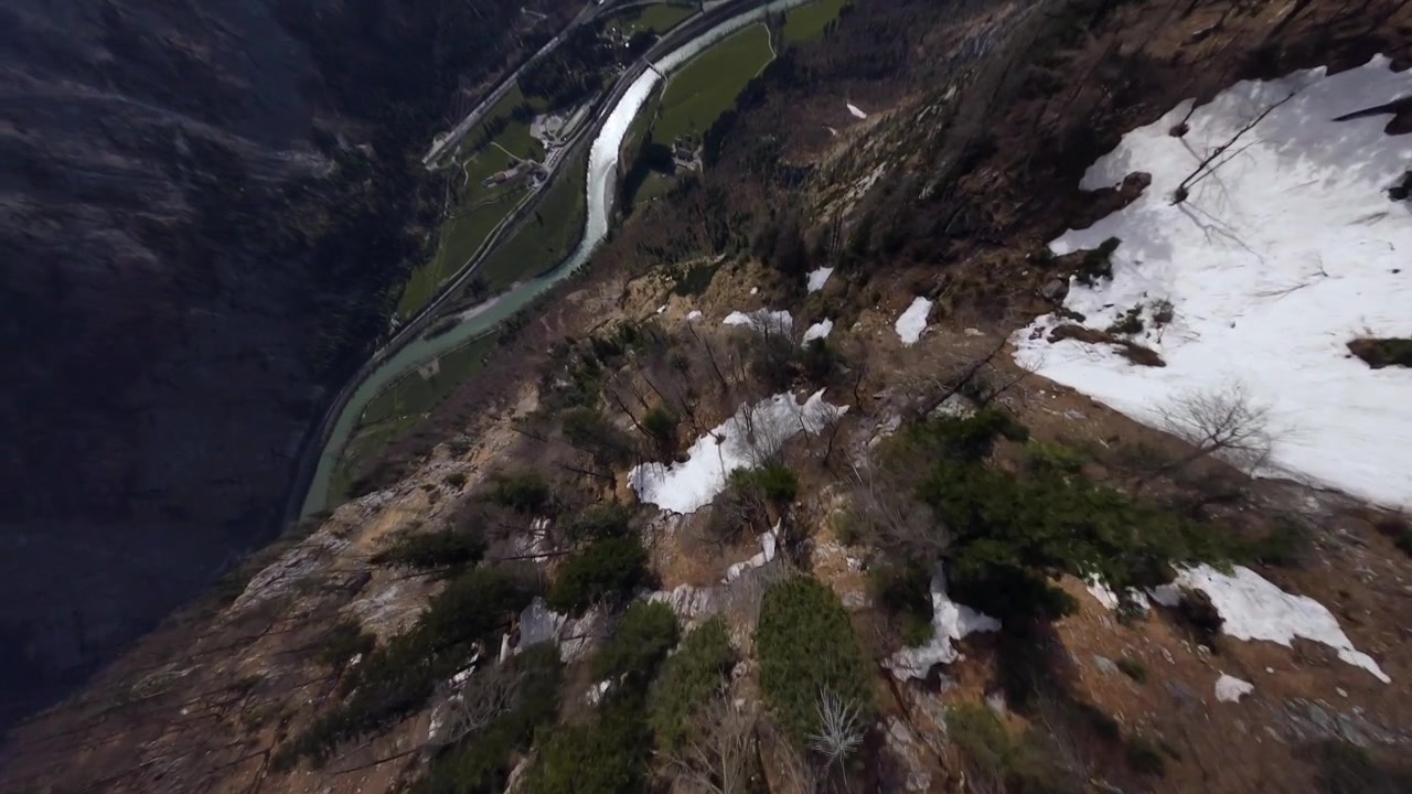 Drone FPV si tuffa tra le montagne austriache innevate attraverso le nuvole all'inizio della primavera in una giornata di sole