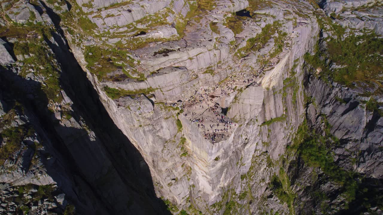 Preikestolen plateau with hikers, tourists and Lysefjord in bright daylight in Norway. Aerial drone