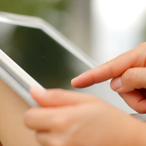 close up on woman hands while using tablet