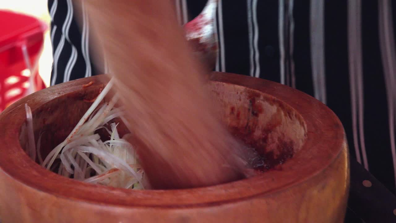Utilizzo di mortaio e pestello per mescolare ingredienti per street food