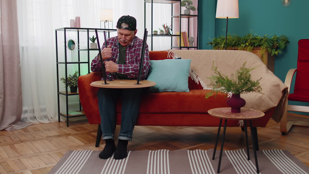 anciano anciano abuelo acabado ensamblaje de muebles en casa mesa recoger, reparar, arreglar