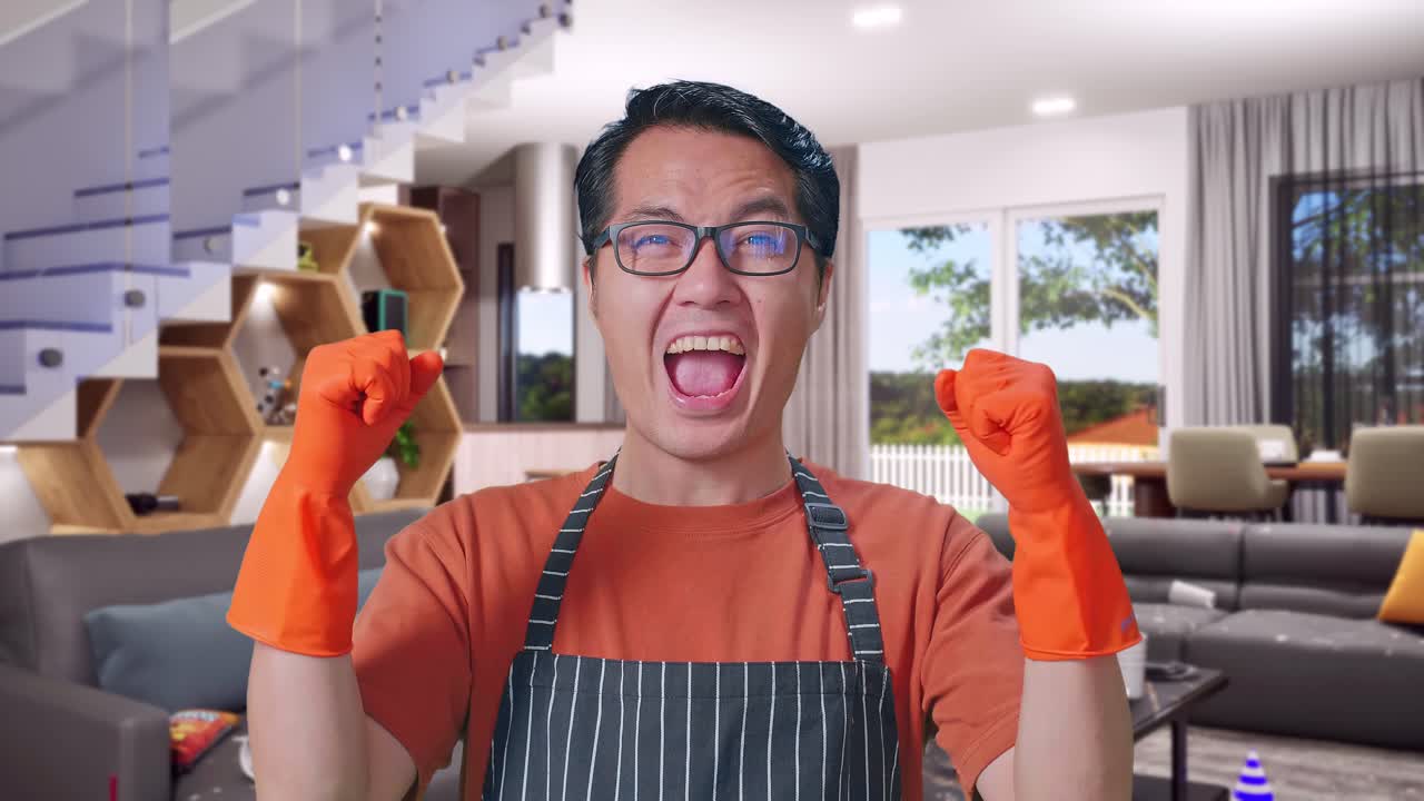 Close Up Of Happy Asian Male Housekeeper With An Apron Celebrating While Standing In House
