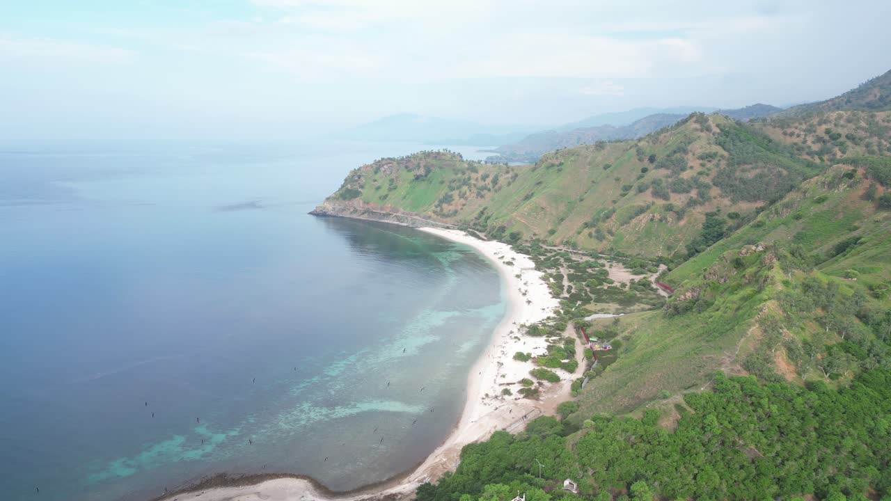 воздушные кадры, показывающие зеленые холмы тимора-лесте, голубой океан и белый песчаный пляж