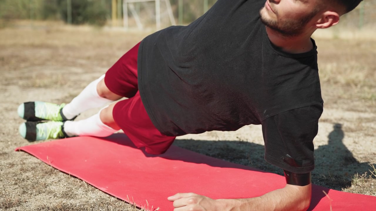 Man Doing Plank On The Left Side For Soccer Training