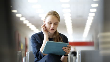 Young-woman-with-pad-sitting-in-the-waiting-room