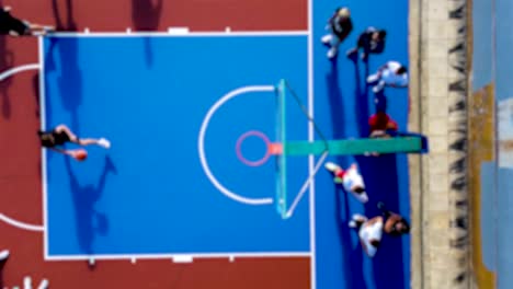 athletics day in schools, young boys playing basketball in schoolyard, blurred aerial footage