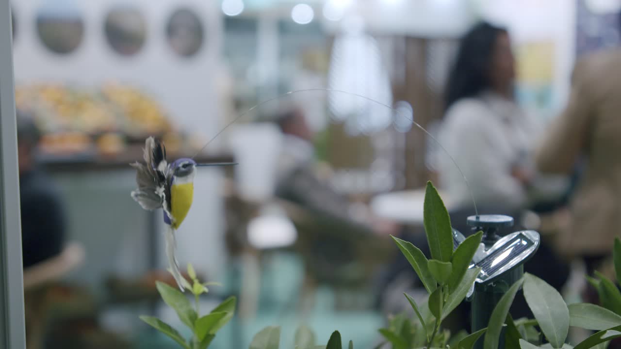 Shot of realistic hummingbird, hovering fake grass, garden decor, solar energy powered