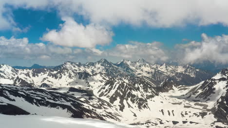 air flight through mountain clouds over beautiful snow-capped peaks of mountains and glaciers