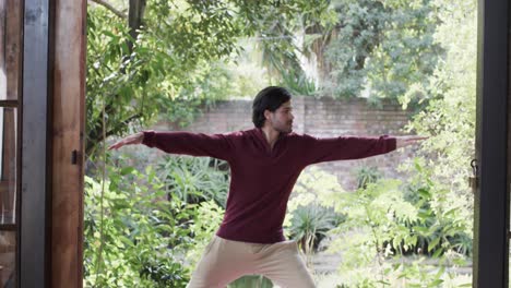 caucasian man practicing yoga on terrace in sunny nature, slow motion