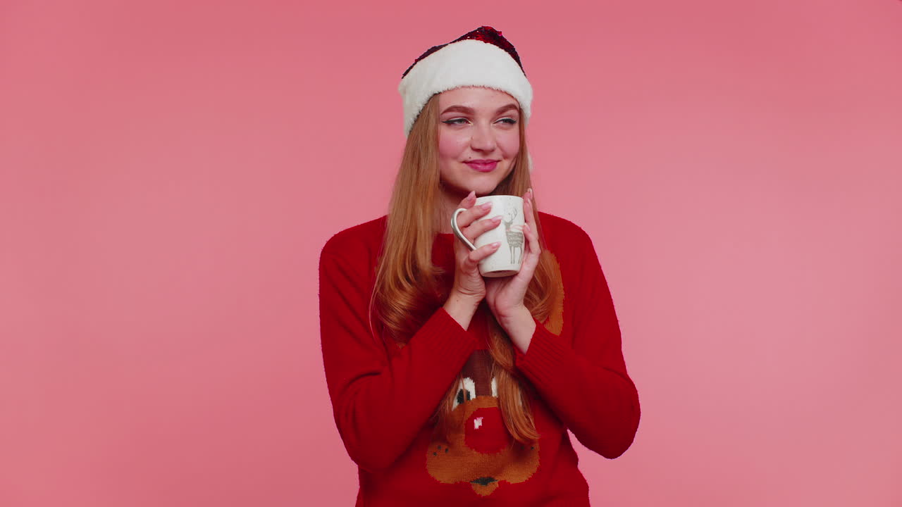 chica alegre en navidad suéter de santa con bebida caliente sonriendo, relajándose, bebiendo café o té