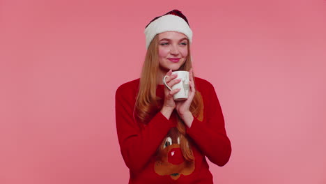 Cheerful-girl-in-Christmas-Santa-sweater-with-hot-drink-smiling,-relaxing,-drinking-coffee-or-tea