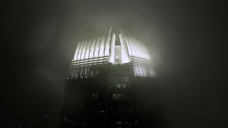 Grattacielo IFC tra le nuvole di notte illuminato dalle luci in cima