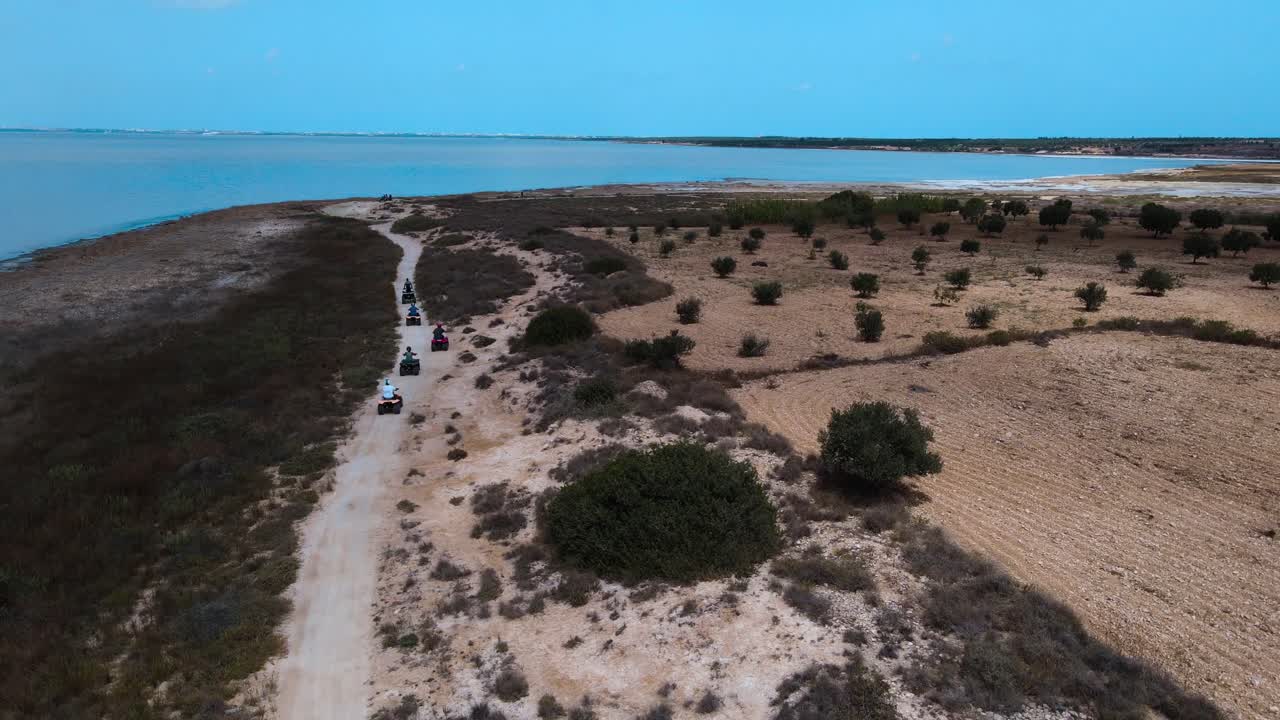 Group ATV Ride on a Dirt Track by a Lake