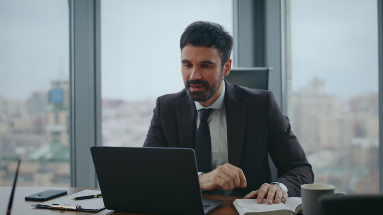 gerente hablando entrevista en línea mirando cámara portátil en oficina de lujo de cerca