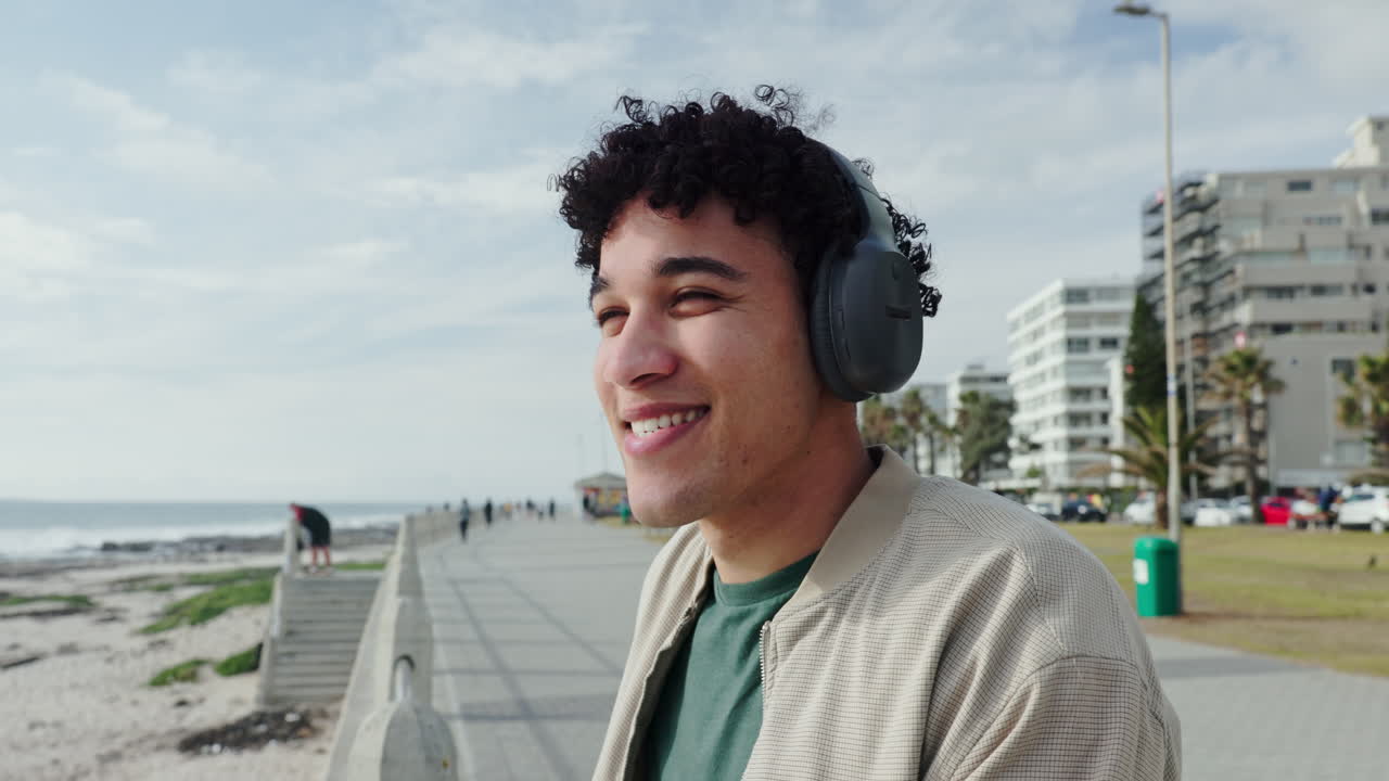 Man listening to music on headphones by the beach