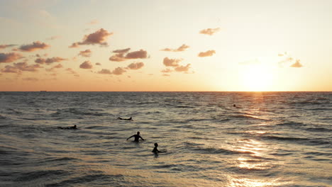 surfers in front of the touristic town domburg in the netherlands during sunset